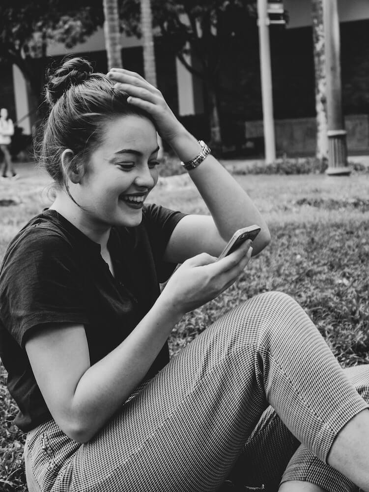 Contact: Picture of a Girl Holding a Phone and smiling